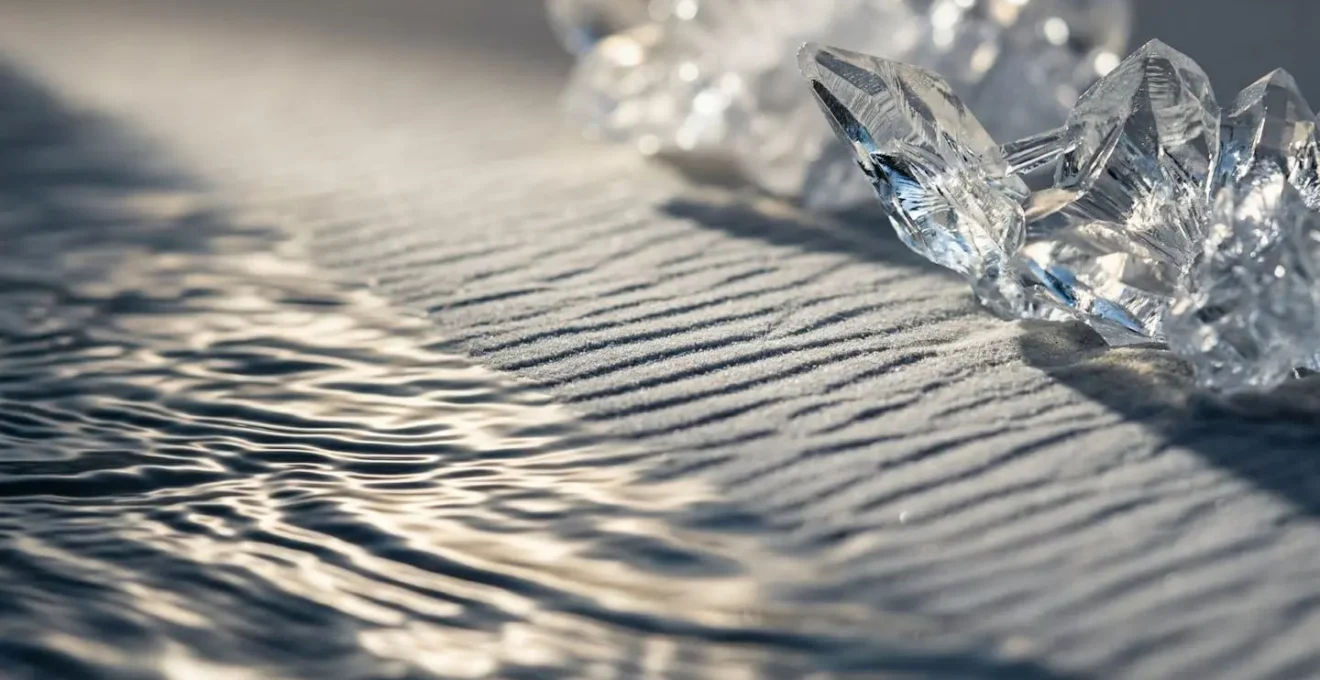 Vue macro détaillée de différentes textures naturelles évoquant les énergies lunaires : eau ondulante, sable fin, cristaux de glace